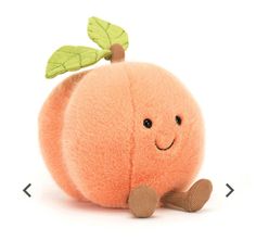 an orange stuffed animal with a green leaf on it's head, sitting in front of a white background