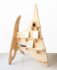 a wooden shelf with books and pictures on it in the shape of a whale's tail