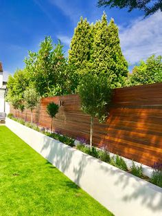 a fenced in backyard with grass and trees