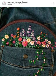 the back pocket of someone's jean jacket with flowers embroidered on it and in between them