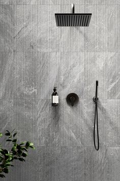 the shower head and hand shower are shown in this bathroom setting with grey marble walls