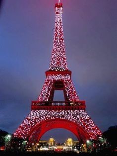 the eiffel tower is lit up in red and white