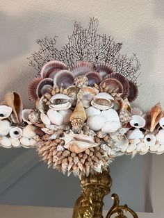 a vase filled with lots of different types of seashells on top of a table