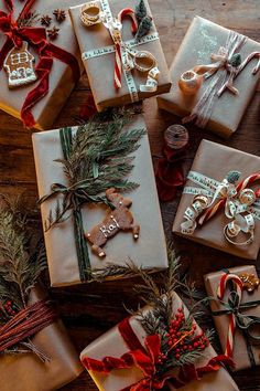 christmas presents wrapped in brown paper and tied with red ribbon on top of a wooden table