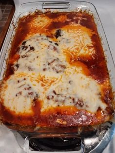 a casserole dish with cheese and meat in it sitting on a stove top