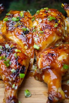 chicken wings with sauce and green onions on a cutting board