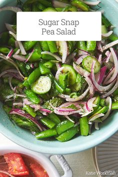 a blue bowl filled with green vegetables next to a white plate full of red onions and cucumbers