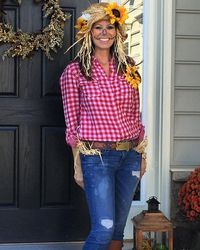 a woman standing in front of a black door wearing a red and white checkered shirt