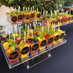 an assortment of fruit is displayed in plastic trays on a table with black cloth