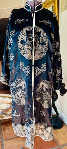 This is a handmade embroidered vintage Chinese black silk robe with embroidered designs dragons with Pearls, bats and other classic Chinese symbols. It is a woman's medium size measuring 16" across the shoulders, 22" long sleeves and it falls to mid calf at 38" long. The lovely robe is fully lined as shown and other than a few gaps in seams which require a few stitches it is in excellent condition. Chinese Silk Robe Dragon, Black Silk Robe, Embroidered Dragon, Embroidered Designs, Chinese Symbols, Silk Robe, Pajama Robe, Womens Robes, Embroidered Design