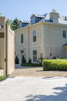 a large brick house with a gated driveway leading into the front yard and entrance