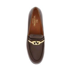 These Valentino Garavani Brown Leather Loafers include a gold-finished metal VLogo Signature detail and a sleek Italian leather construction. A round toe, cushioned insole, and durable leather sole add luxury and comfort. Luxury Gold Loafers In Calf Leather, Luxury Gold Calf Leather Loafers, Luxury Designer Brown Loafers, Brown Fondant, Semi-formal Calf Leather Loafers With Textured Sole, Luxury Brown Slip-on Tassel Loafers, Brown Leather Loafers, Makeup Travel Case, Plastic Pollution