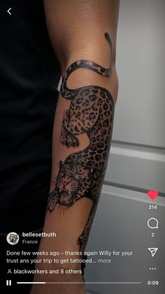 a person with a tattoo on their arm that has a black and grey leopard on it