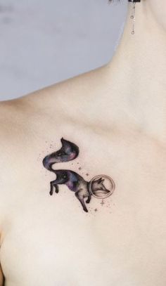 a woman's chest with a cat tattoo on the left side of her body