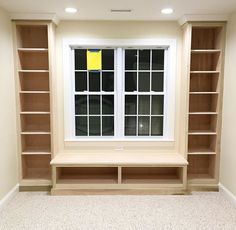 an empty room with bookshelves and windows