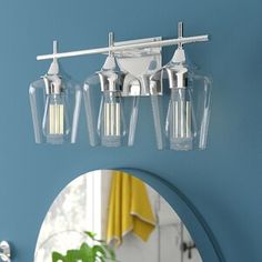 three light bathroom fixture in chrome finish with clear glass shades on the bulbs and mirror