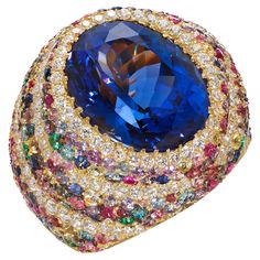 Rosior One-off Cocktail Ring set in Yellow Gold with: - 1 oval cut, GIA certified, tanzanite weighing 11,86 ct. - 153 multicolor sapphires weighing 2,98 ct; - 108 colorless diamonds (F color, VVS clarity) weighing 0,94 ct; - 33 pink sapphires weighing 0,51 ct; - 31 brown sapphires weighing 0,22 ct; - 26 blue sapphires weighing 0,49 ct; - 13 blue diamonds weighing 0,22 ct; - 12 emeralds weighing 0,16 ct; - 5 yellow diamonds weighing 0,04 ct. Weight in 19.2K gold: 10.8 g. Unique piece. Handmade in