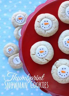 a red plate topped with frosted snowmen on top of a blue tablecloth