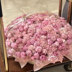 a basket filled with pink flowers sitting on top of a table