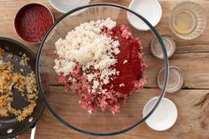 the ingredients are in bowls on the wooden table next to each other, including meat and cheese