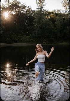 a woman standing in the water with her arms outstretched