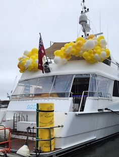 a large white boat with yellow and white balloons on it