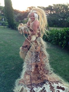 a woman in a long dress standing on the grass