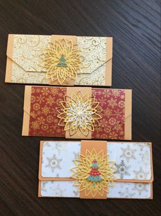 three handmade cards on a table with flowers in the middle and gold trimmings