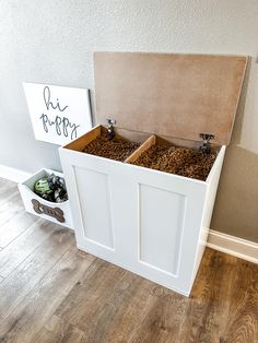 two wooden boxes filled with coffee beans sitting on top of a hard wood floor next to a sign