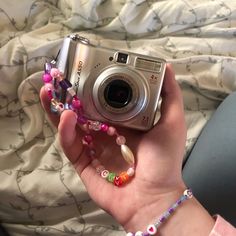 a person holding a camera and some beads