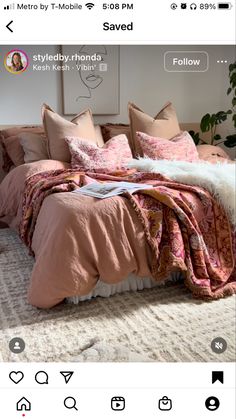 a bed with pink sheets and pillows in a room next to a painting on the wall