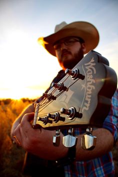 A guy in a cowboy hat with his guitar pointed at the camera Cool Band Pictures, Melanie Photoshoot, Boyish Photoshoot, Country Band Photoshoot, Guitar Photoshoot Ideas, Music Photography Creative, Band Poses With Instruments, Photo Shoot With Guitar, Country Music Photoshoot