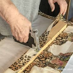 a person cutting fabric with a pair of scissors