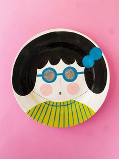 a paper plate with an image of a woman's face and glasses on it