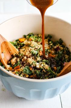 a wooden spoon pouring dressing into a bowl