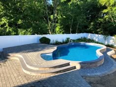 a backyard with a swimming pool surrounded by trees