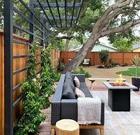 an outdoor living area with couches, tables and fire pit in the middle of it