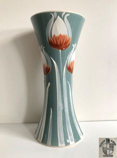 a blue vase with orange flowers painted on it