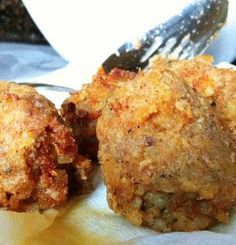 three fried food items on a plate with a knife and fork next to it,