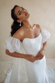 a woman in a white dress posing for the camera