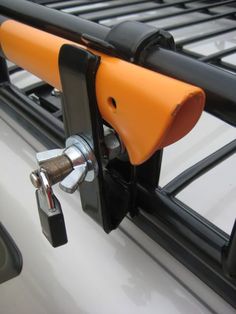 an orange and black handlebar attached to a white vehicle with metal bars on it