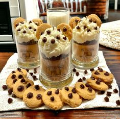 cookies and ice cream in glass jars with chocolate chips on the table next to them