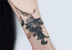 a woman's arm with a flower tattoo on it