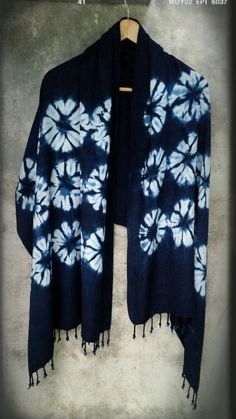 a blue and white tie - dyed shawl hanging on a wall