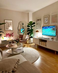 a living room filled with furniture and a flat screen tv on top of a wooden floor