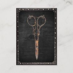 a pair of scissors with metal handles on a marble surface in the shape of a heart