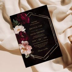 a black and gold wedding card with flowers on it