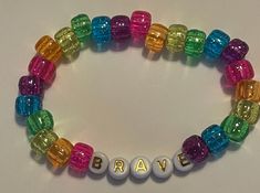 a bracelet with the word brave spelled out in white letters and multicolored beads