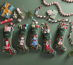 christmas stockings and other holiday decorations are displayed on a green surface with beads, bows, and ornaments