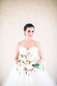 a woman in a wedding dress holding a bouquet